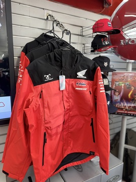 Honda HRC jackets on display next to FOX hats and other riding apparel inside the showroom.