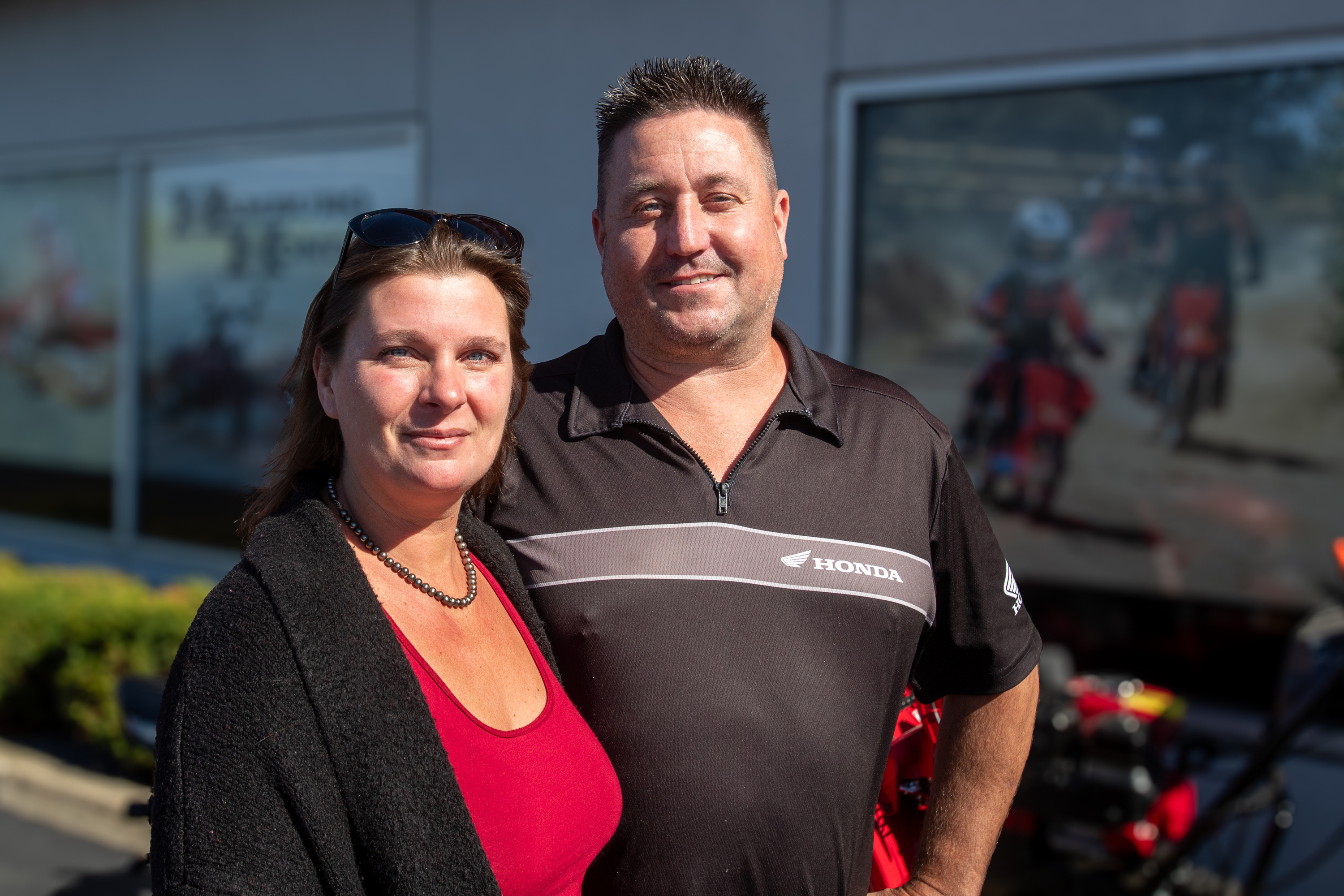 Ashley and Brian, day-to-day operations leaders at Hamburg Honda, standing outside the dealership.