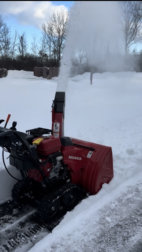 Honda HSS1332ATD track-drive snowblower clearing deep snow on a Buffalo NY job site.